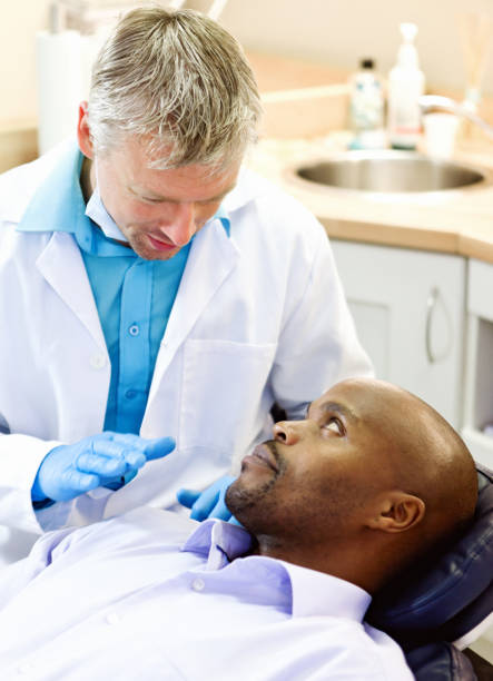 istock Dentist reassuring his nervous patient 1156666325