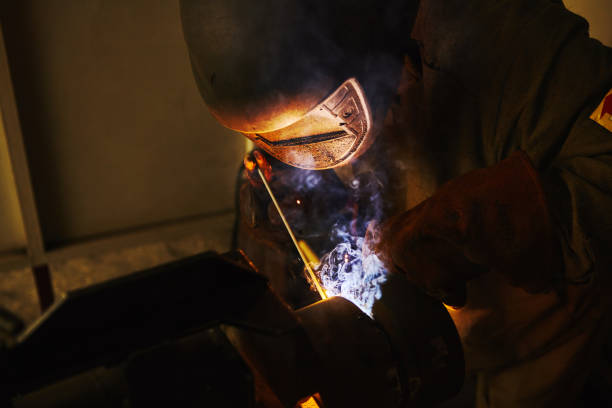 istock Male in face mask welds with welding 1156671229