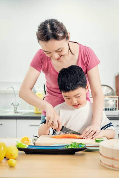 istock Senior woman chopping Salmon with her son in kitchen 1156671626