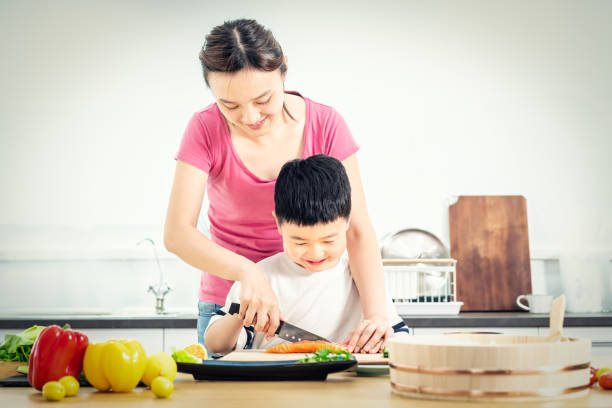 istock Senior woman chopping Salmon with her son in kitchen 1156671629