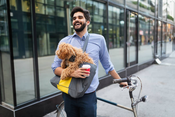istock Handsome smiling man sitting on a bicycle on the street and drinking coffee. 1156671688