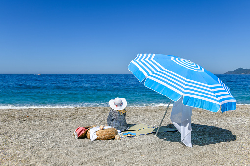 blue beach umbrella on the sand, background mediterranean sea