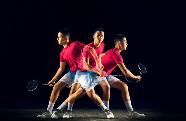 istock Little boy playing badminton isolated on black studio background 1156673992