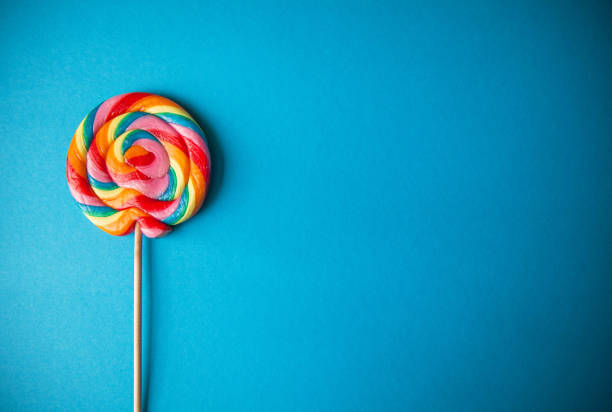 istock Colorful rainbow lollipop, blue background, left sided, with copy space 1156678781