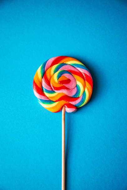 istock Colorful rainbow lollipop, blue background, centered, vertical 1156679644