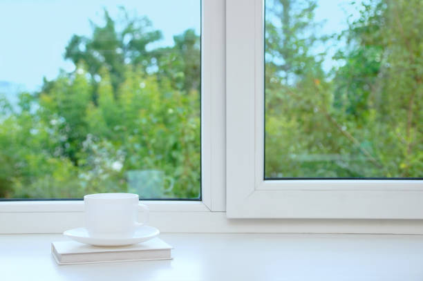 istock White cup and saucer on the window in the summer. 1156680877
