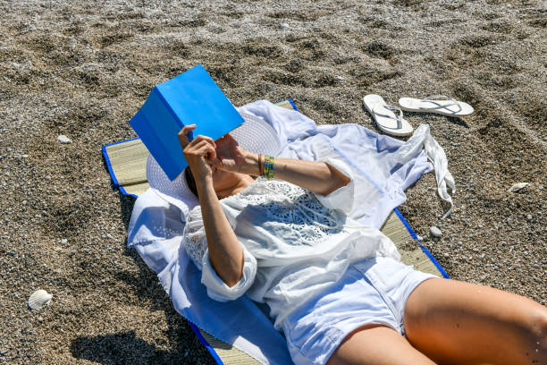 istock Woman studying book at the beach. 1156682039