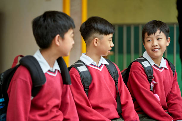 istock Smiling schoolboy talking with friends in campus 1156684715