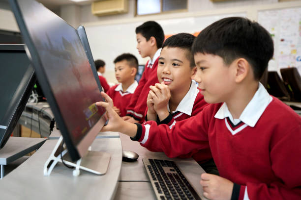 istock Curious schoolboys looking at computer monitor 1156684737