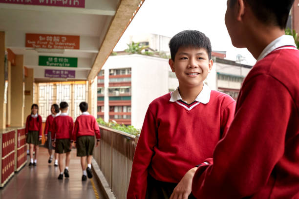 istock Smiling schoolboy looking at friend in corridor 1156684787