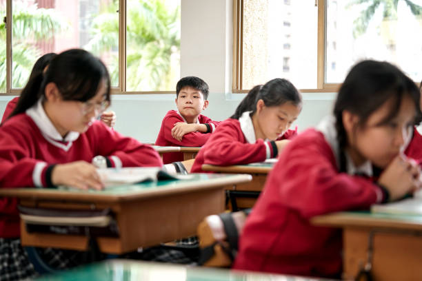 istock Schoolboy looking away at desk in classroom 1156684791