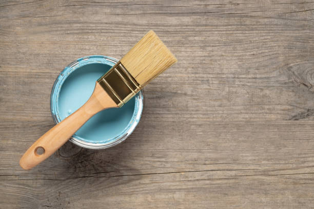 istock Paint brush and can on wooden table 1156685360