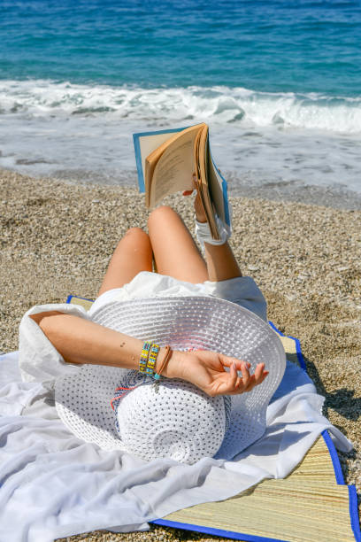istock Woman studying book at the beach. 1156686652
