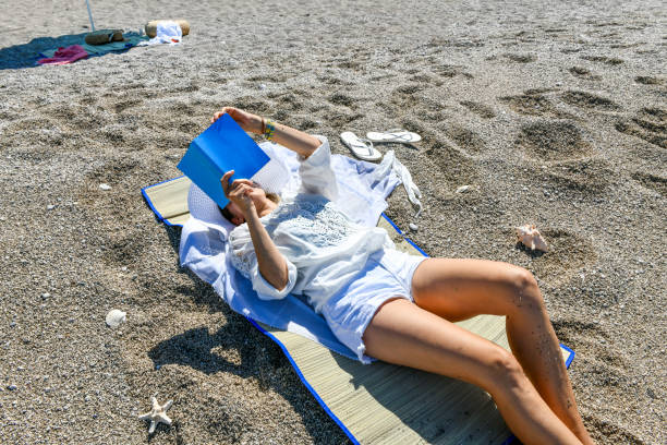 istock Woman studying book at the beach. 1156687042