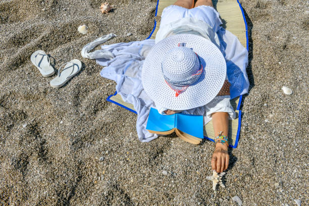 istock Woman lying on beach hands out starfish 1156690277