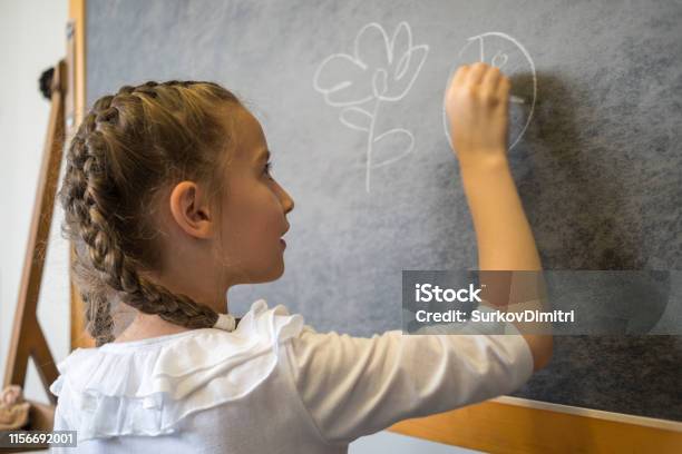 Elementary Student Drawing On Blackboard Stock Photo - Download Image Now - 6-7 Years, Apron, Chalkboard - Visual Aid