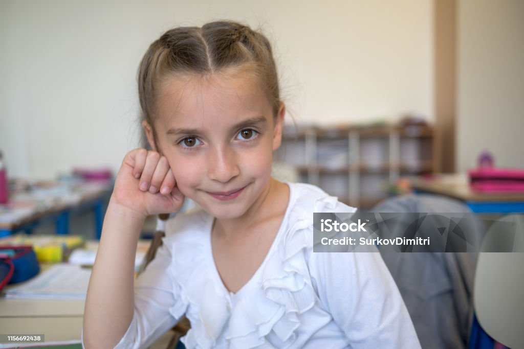 Elementary school student in classroom Pretty elementary school girl posing at camera 6-7 Years Stock Photo