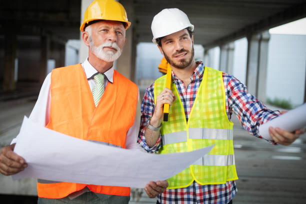 istock Confident team of architects and engineers working together on construction site 1156693526