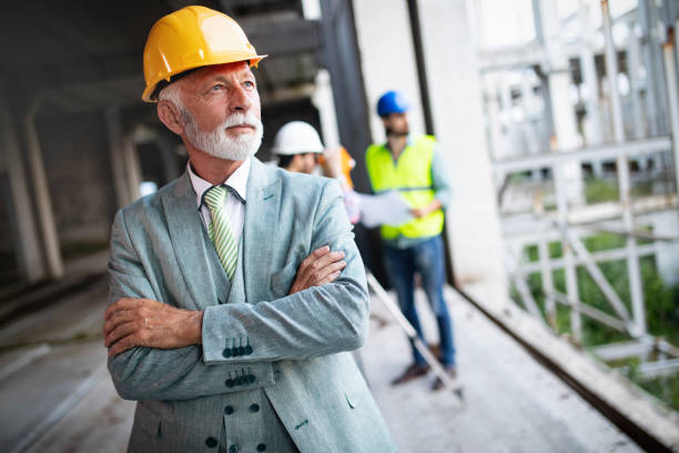 istock Confident team of architects and engineers working together on construction site 1156693797