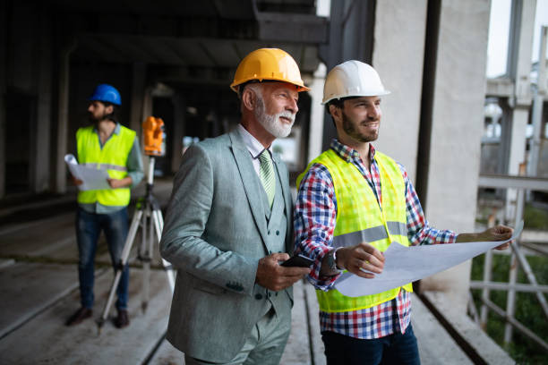 istock Confident team of architects and engineers working together on construction site 1156693905