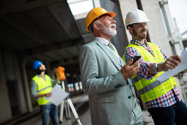 istock Team of business people in group, architect and engeneer on building site check documents 1156693917