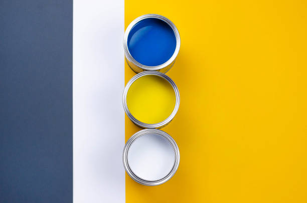istock Three cans of multicolored paint on a gray-orange with a white background. 1156694101