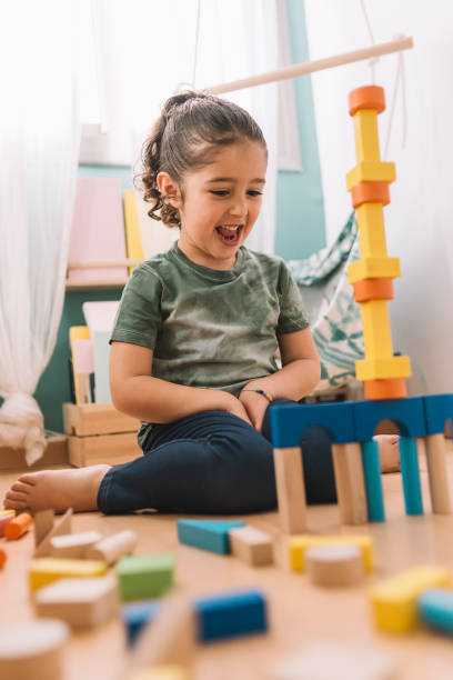 istock happy girl making constructions with wooden blocks 1156696177