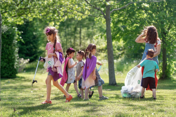 istock Educator and kids cleaning garbage from a park 1156697731