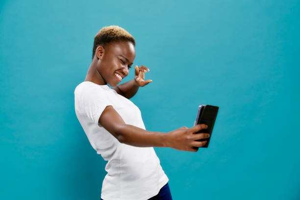 веселая африканская женщина в белой рубашке делает селфи - sport white women fashion model стоковые фото и изображения