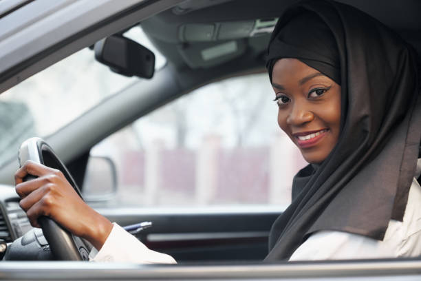 istock Woman in black hijab and looking at camera while driving 1156698008