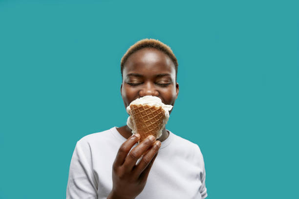 istock Pretty african with closed eyes keeping waffle of ice cream 1156698024