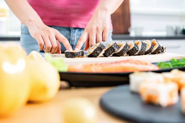 woman preparing sushi in domestic kitchen - sushi japanese culture food domestic kitchen imagens e fotografias de stock