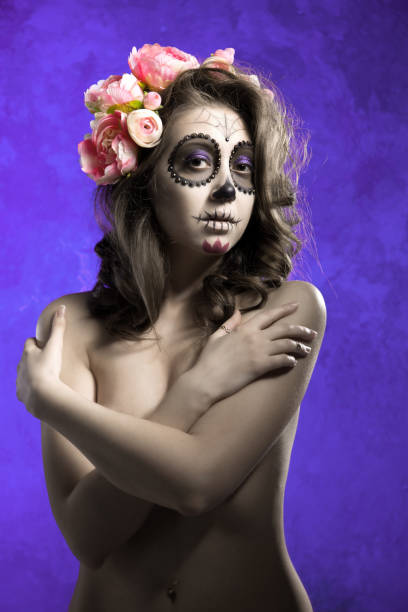 junge halbnackte mädchen in einem kranz von blumen auf einem lila hintergrund. mädchen-skelett. - day of the dead mexico bride human skeleton stock-fotos und bilder