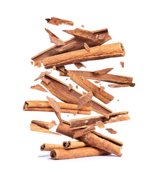 cinnamon sticks are falling down on a pile,isolated on a white background - canella imagens e fotografias de stock