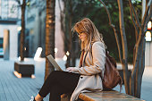 Woman using laptop on a bench