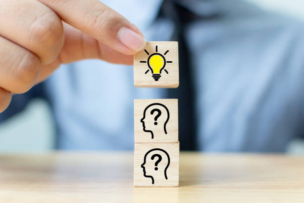 istock Concept creative idea and innovation. Hand picked wooden cube block with head human symbol and light bulb icon 1156712194