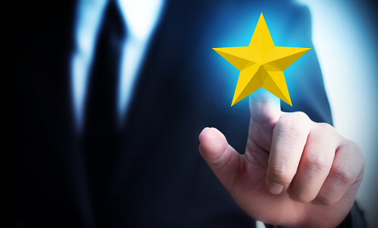 Businessman hands touch a five-star gold shape. The best excellent business services rating customer experience concept