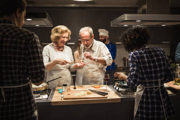 pareja de la tercera edad preparando la comida - cooking senior adult healthy lifestyle couple fotografías e imágenes de stock