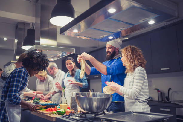istock Chef is supervising attendees of cooking class while they are making meals 1156713341