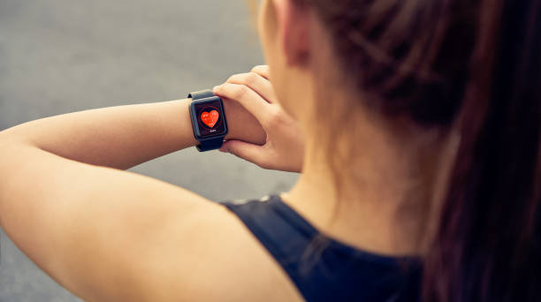 Young woman checking the sports watch measuring heart rate and performance after running. stock photo