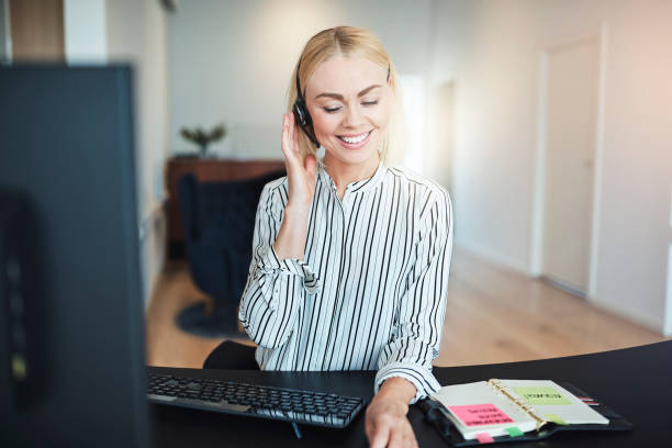 istock Businesswoman working at her desk and talking on a headset 1156716376