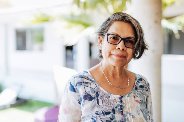 Image of healthy senior Latinx woman with gray hair and eyewear. Senior Latino couple enjoying weekend with their grandchildren and family at home in summertime. mexican ethnicity photos stock pictures, royalty-free photos & images