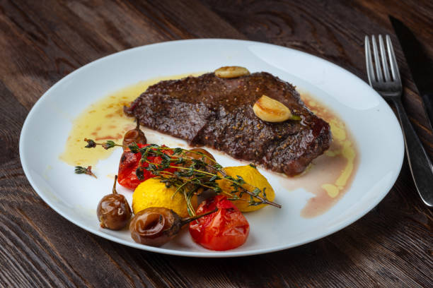 istock Rib-eye steak with baked vegetables resting on a white plate 1156717048