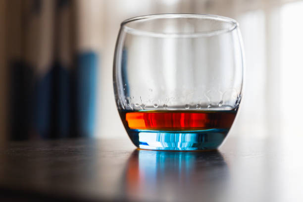istock Glass of whiskey stands on a table 1156721364
