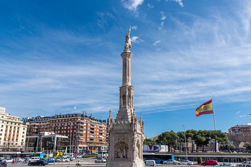 View of Christopher Columbus monument at Madrid city, Spain. At the background the world´s biggest spanish flag.