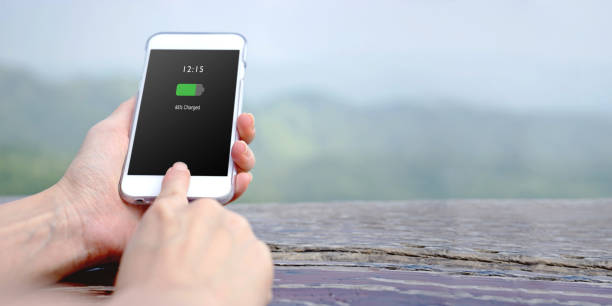 istock Female hand holding mobile phone with charged battery on screen 1156722914