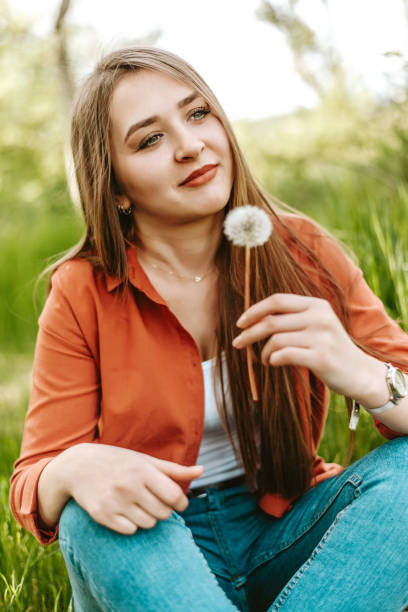 istock Beautiful Young Woman with Dandelion 1156724584