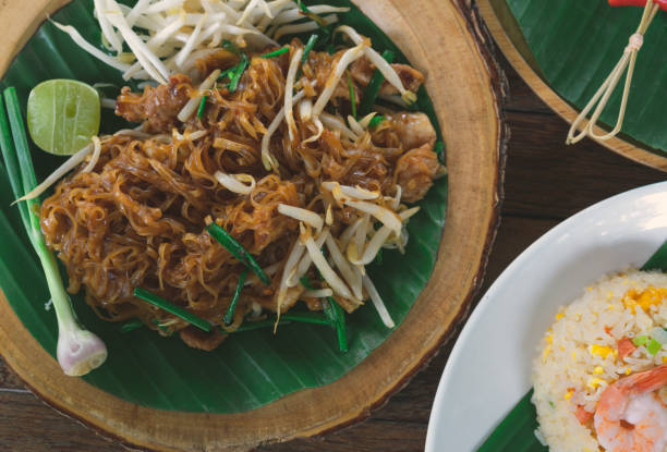 パッドミーコラットタイ料理のオーバーヘッドビューチキンヌードルとチャーハン炒め - banana leaf food thailand thai culture ストックフォトと画像