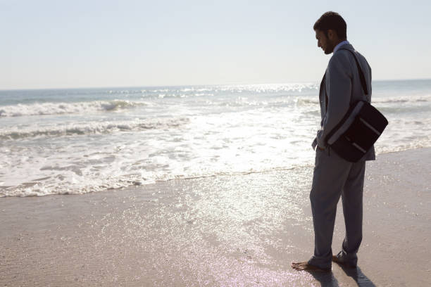 istock Young Businessman standing on the beach 1156726123