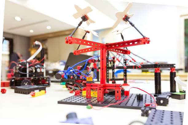 Close-up of amusement park ride model on desk in STEM class. Creative robotics project in classroom. Various metallic objects at table in class.
